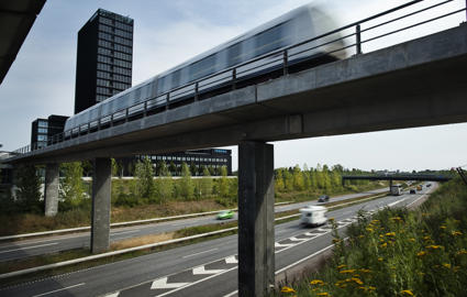 Københavns metro kører på en bro over en flerfeltsvej.