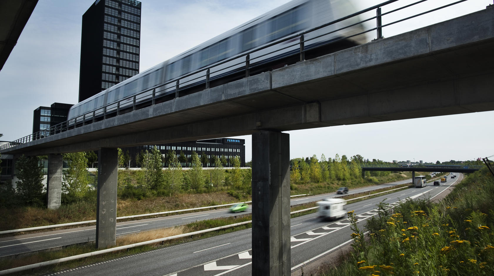 Københavns metro kører på en bro over en flerfeltsvej.